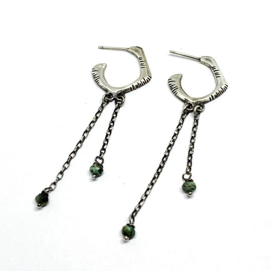 A pair of sterling silver oxidized and brushed finish earrings with turquoise drops and a chain design.