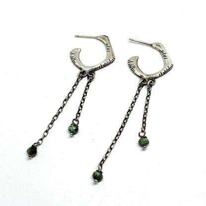 A pair of sterling silver oxidized and brushed finish earrings with turquoise drops and a chain design.