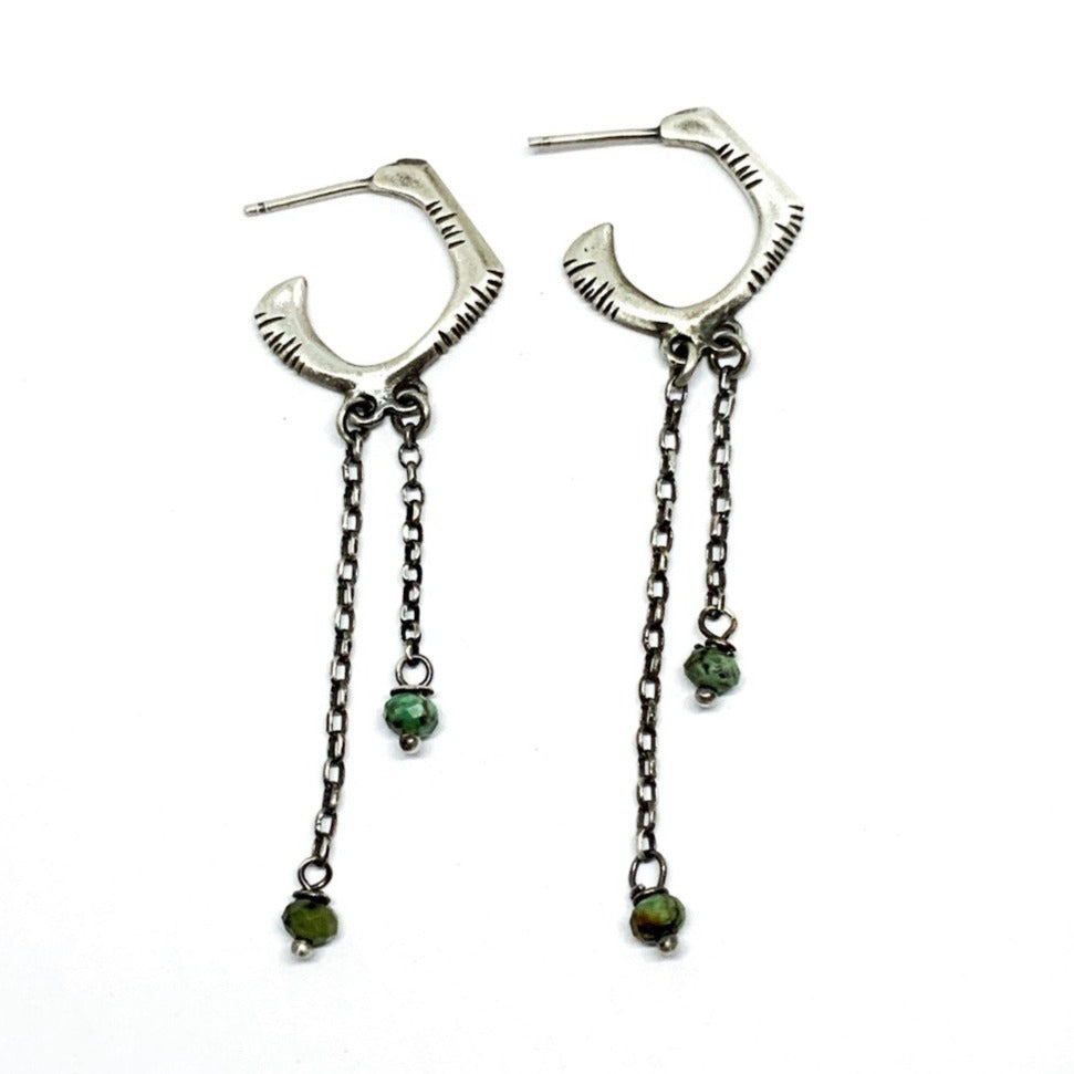 A pair of sterling silver oxidized and brushed finish earrings with turquoise drops and a chain design.