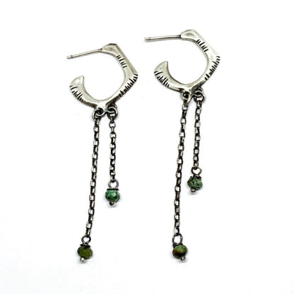 A pair of sterling silver oxidized and brushed finish earrings with turquoise drops and a chain design.