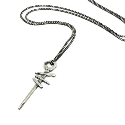 A silver necklace with a pendant featuring a symbol, attached to a chain.
