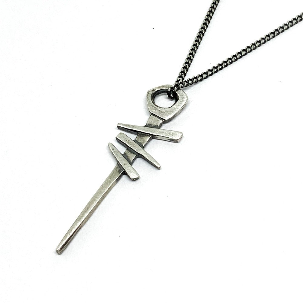 A silver necklace with a pendant featuring a symbol, attached to a chain.