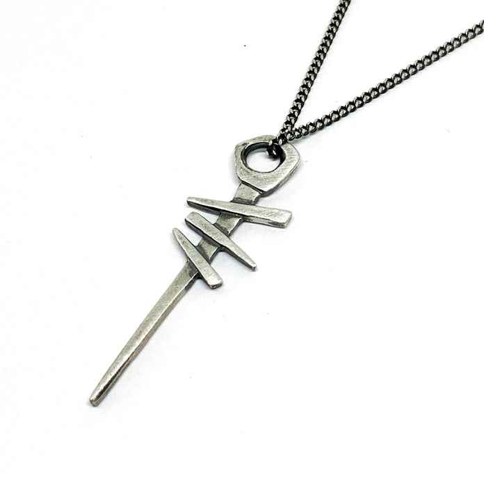 A silver necklace with a pendant featuring a symbol, attached to a chain.