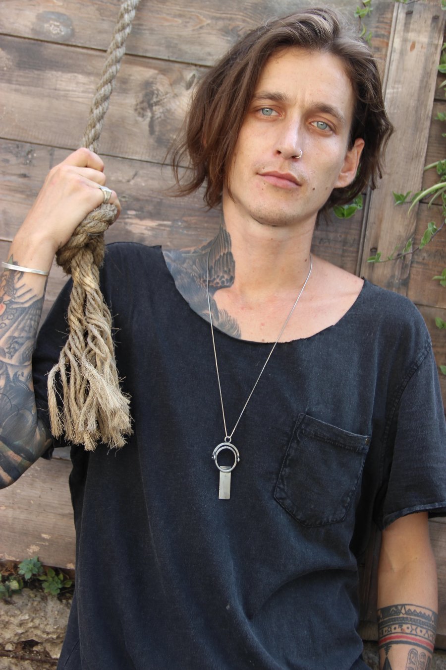 A sterling silver necklace with a magnifying glass pendant and a cross on the chain.