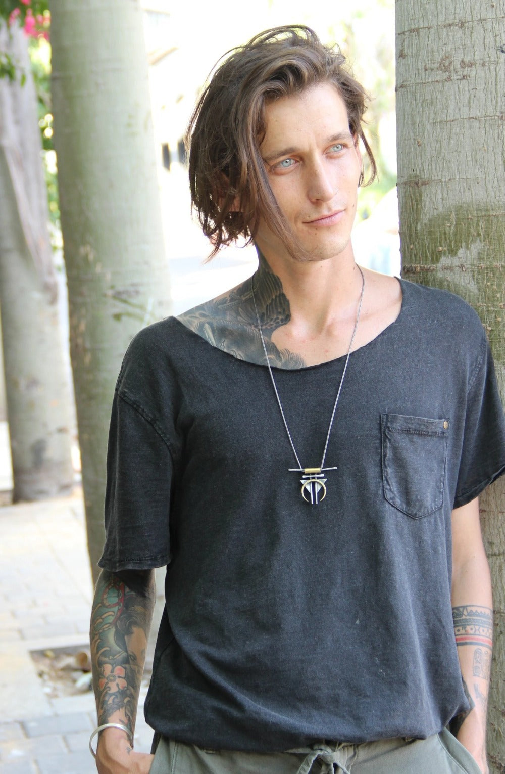 A silver and gold-colored necklace with a geometric pendant, featuring a chain and a series of geometric shaped pendants attached to it.