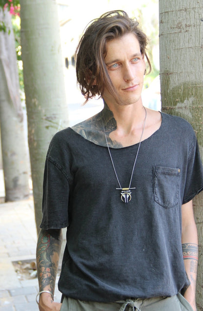 A silver and gold-colored necklace with a geometric pendant, featuring a chain and a series of geometric shaped pendants attached to it.