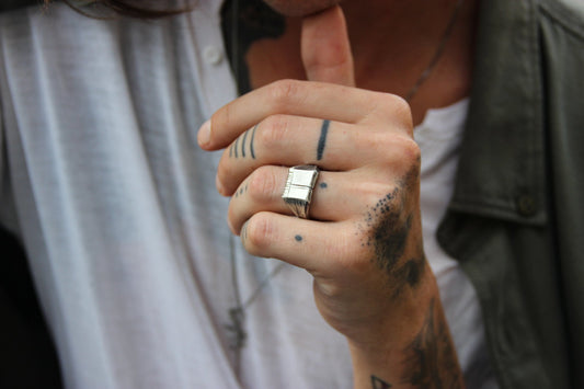 A silver carved memories ring with a textured and embossed pattern