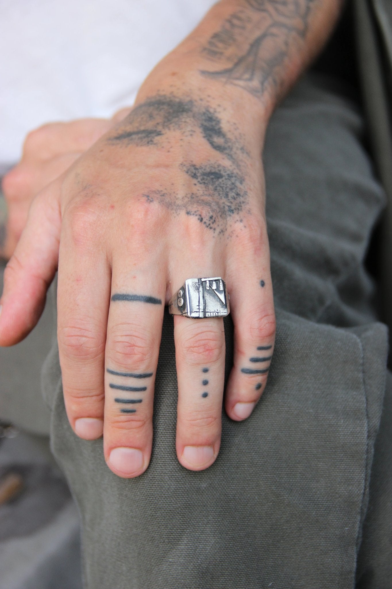 A silver, oxidized and brushed finish ring with a geometric design, signet-style