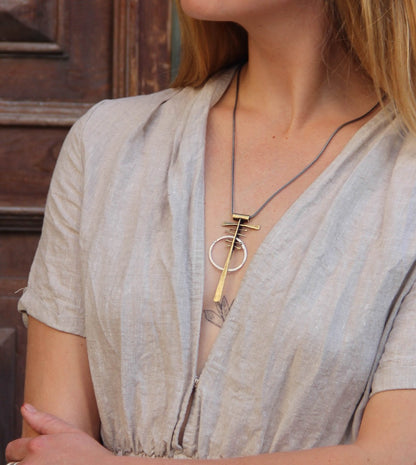 A silver and brass necklace with a geometric pendant
