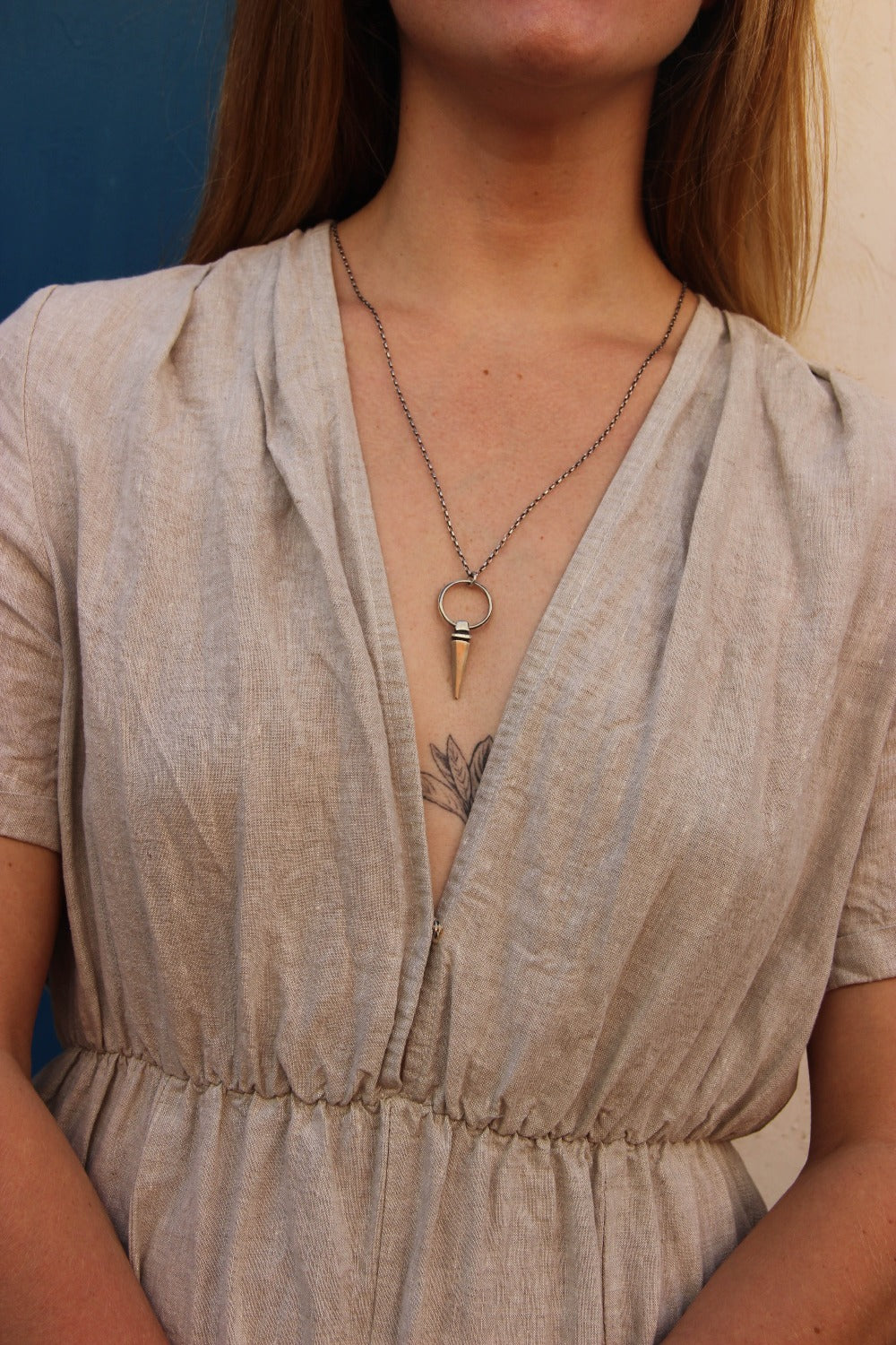 A sterling silver pendulum necklace with a brushed finish and a chain loop at the top. The pendulum is large and has a smooth, polished appearance.
