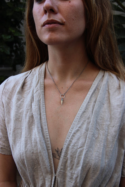 A sterling silver pendulum necklace with a brushed finish and a chain loop at the top.