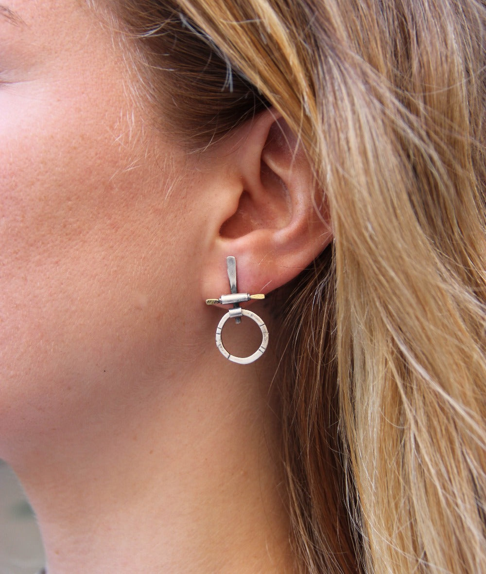 A pair of silver and brass earrings with a geometric design
