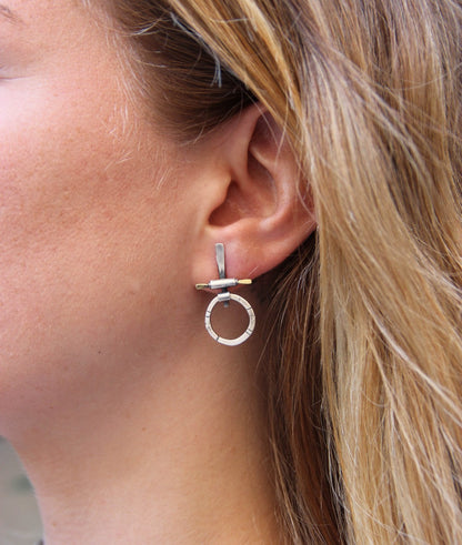 A pair of silver and brass earrings with a geometric design