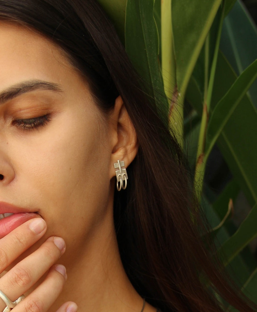 A pair of silver oxidized and brushed finish earrings with a geometric design