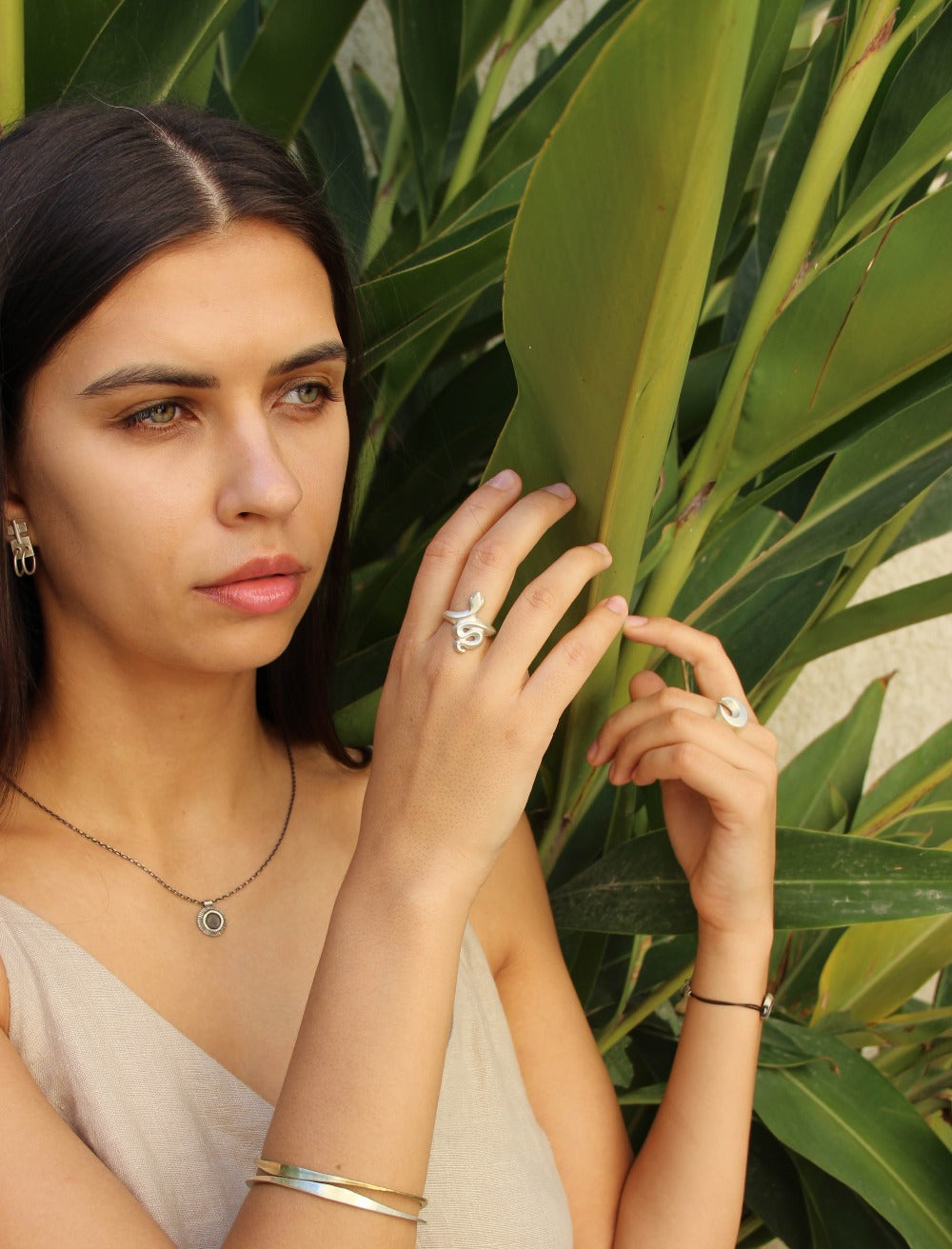 A silver ring featuring a brushed finish, handcrafted in the shape of a snake.