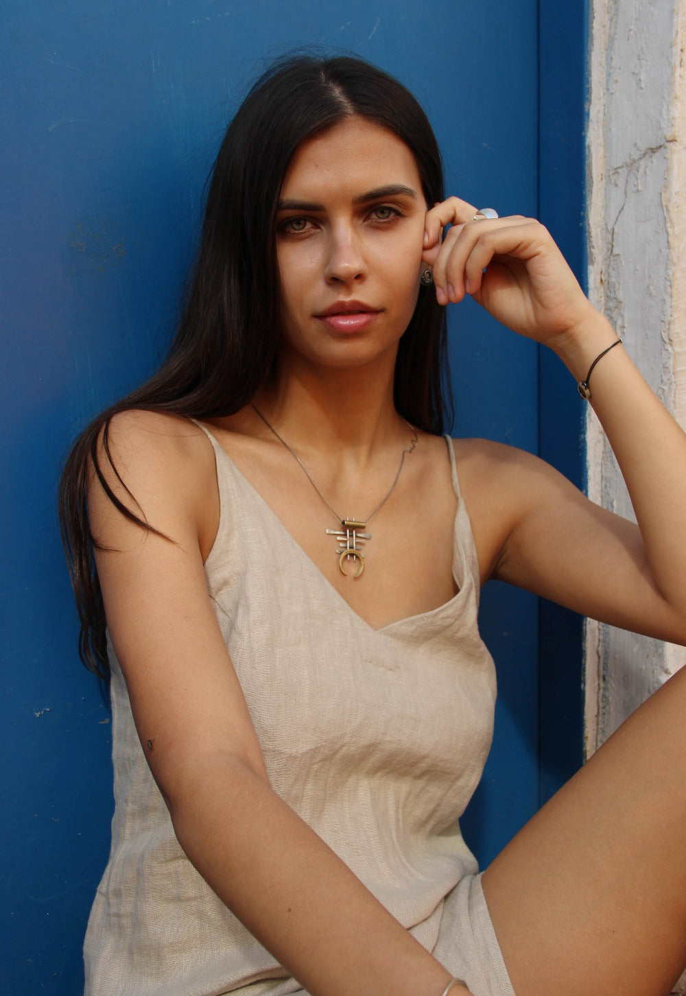 A necklace with a unique geometric pendant made of silver and brass, featuring an oxidized and brushed finish.