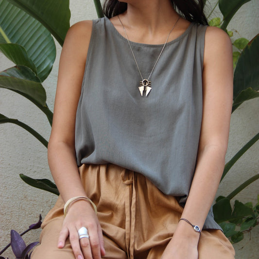 A necklace with a geometric silver pendant featuring a combination of brushed and oxidized finishes, attached to a chain.