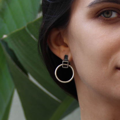 A pair of silver oxidized and brushed finish earrings with a geometric design