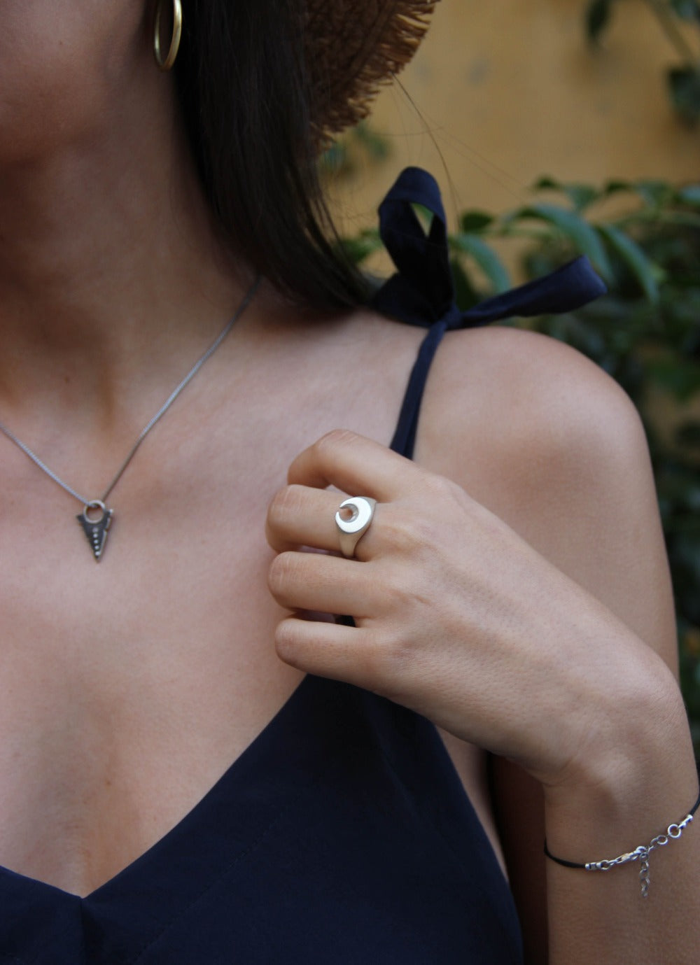 A silver ring featuring a brushed finish, handcrafted in the shape of a moon.