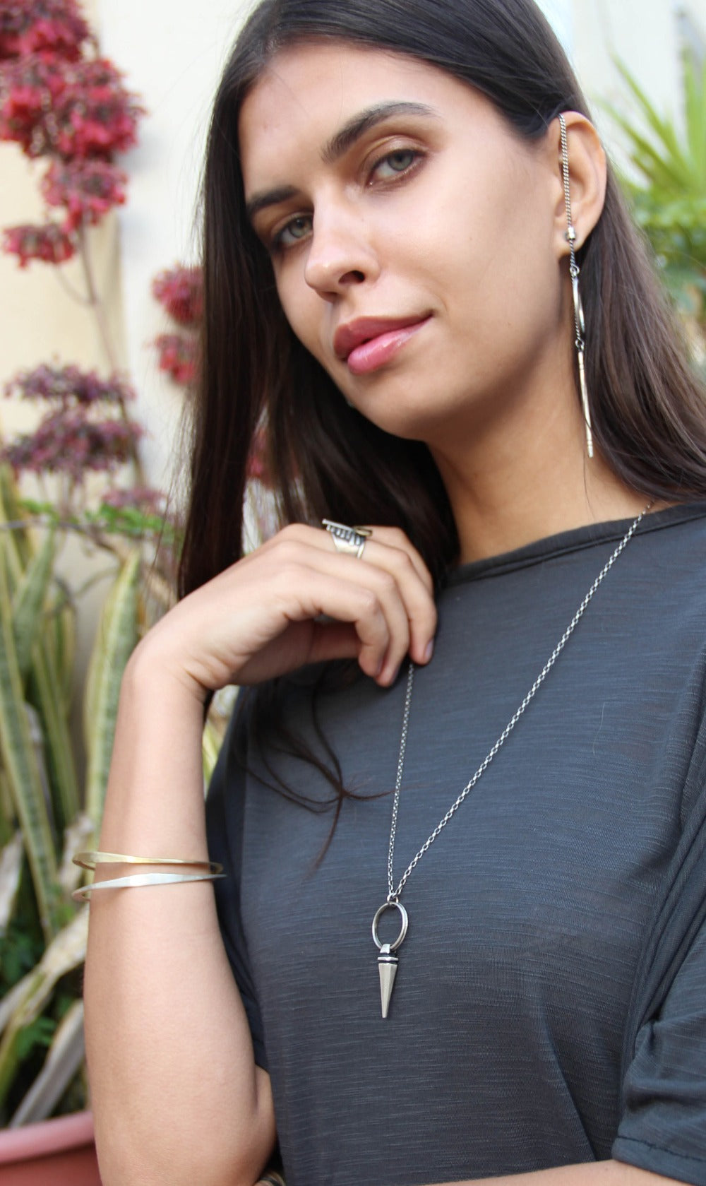 A sterling silver pendulum necklace with a brushed finish and a chain loop at the top. The pendulum is large and has a smooth, polished appearance.