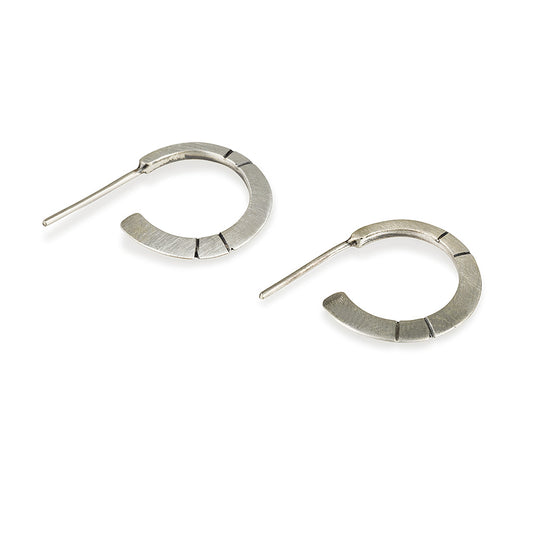 A pair of oxidized silver hoop earrings with a brushed finish, displayed against a white background.