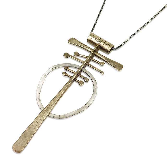 A silver and brass necklace with a geometric pendant