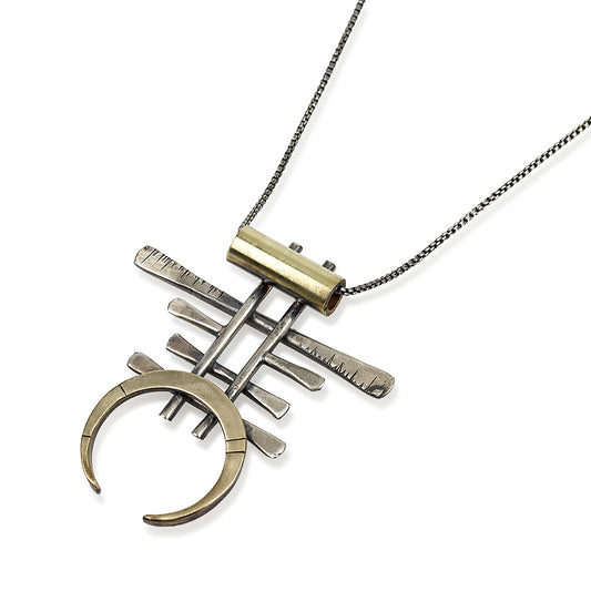A necklace with a unique geometric pendant made of silver and brass, featuring an oxidized and brushed finish.