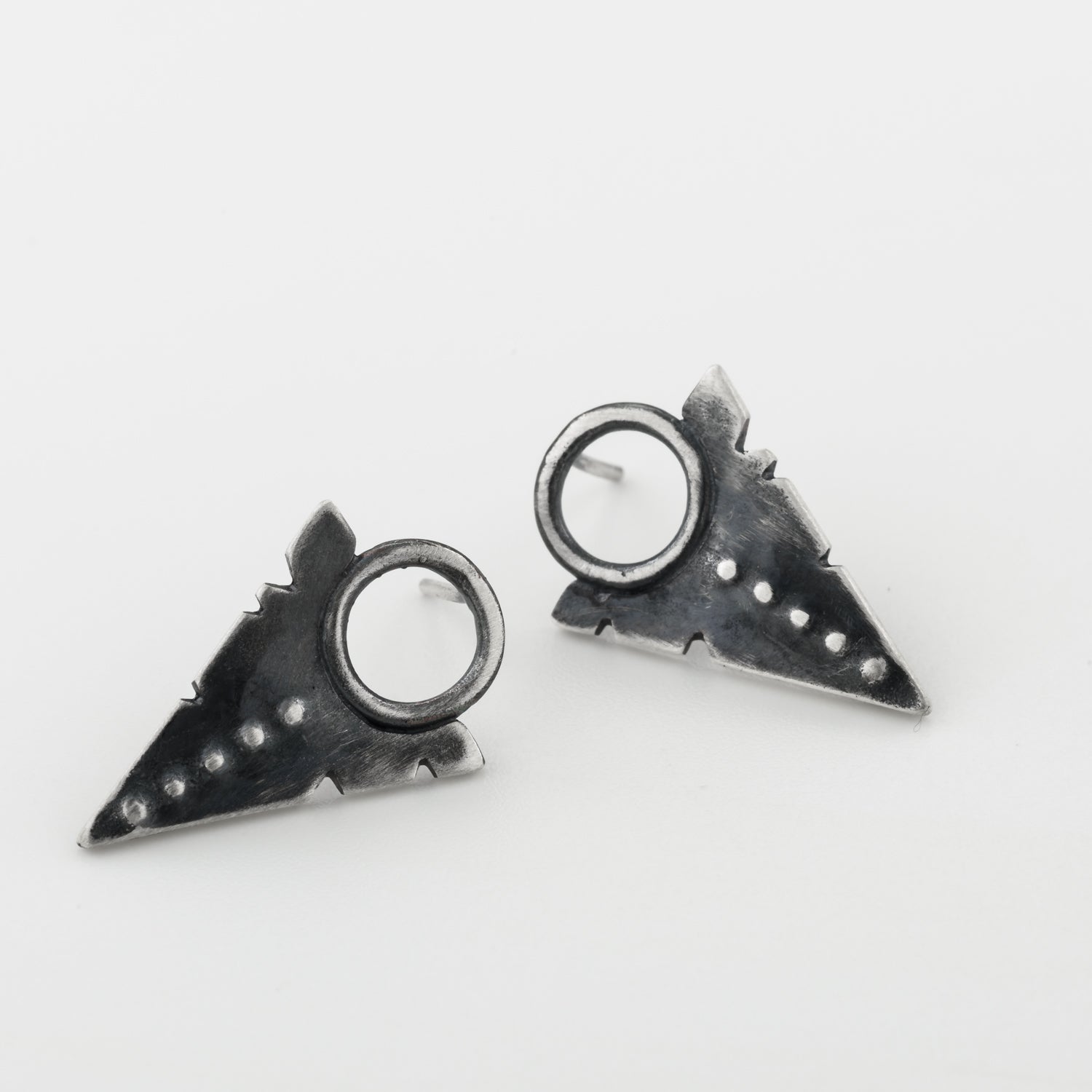 A pair of silver oxidized and brushed finish dotted path earrings on a white background