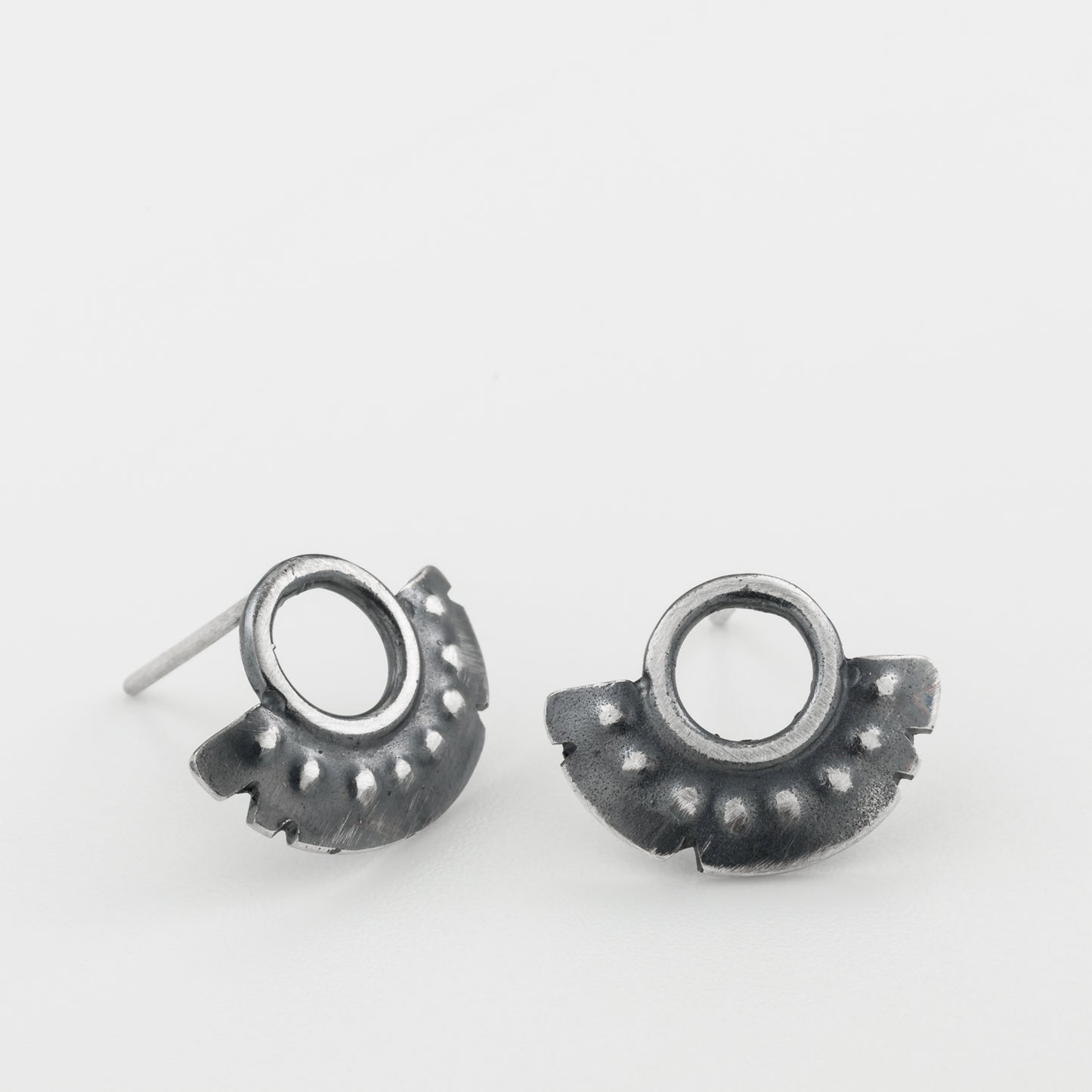 A pair of oxidized sterling silver dotted half moon earrings with a brushed finish, displayed against a white background.
