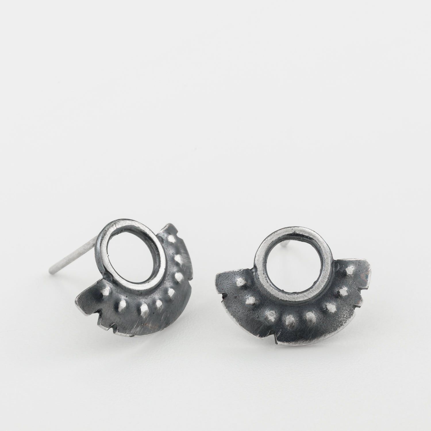 A pair of oxidized sterling silver dotted half moon earrings with a brushed finish, displayed against a white background.
